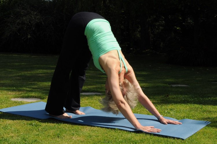 Sarah Church in garden practising yoga in Guildford, Surrey.