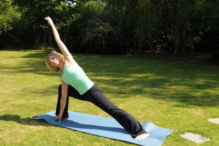 Sarah Church doing garden yoga at The Oaks, Normandy